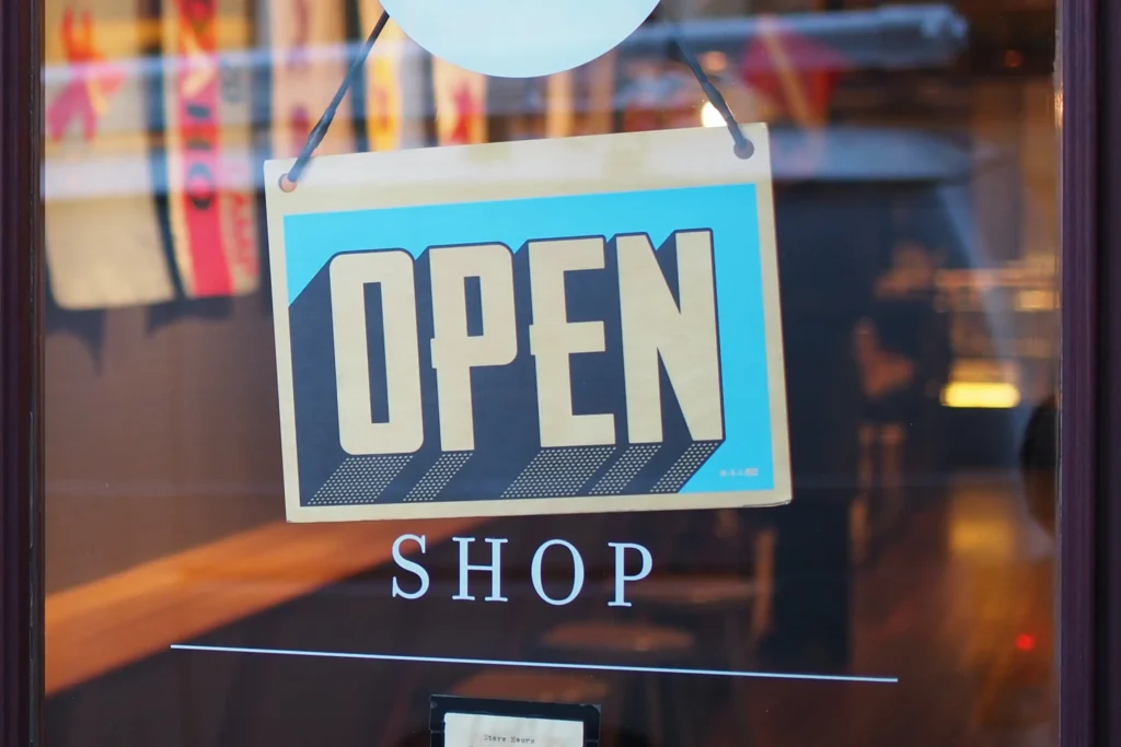 An "open" sign hanging on a shop door.